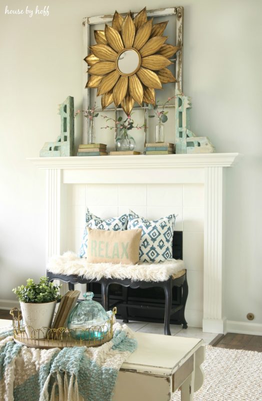 A white fireplace with a rug in front of it.