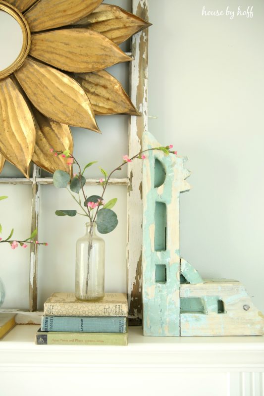  A clear vase with delicate pink flowers on the mantel.