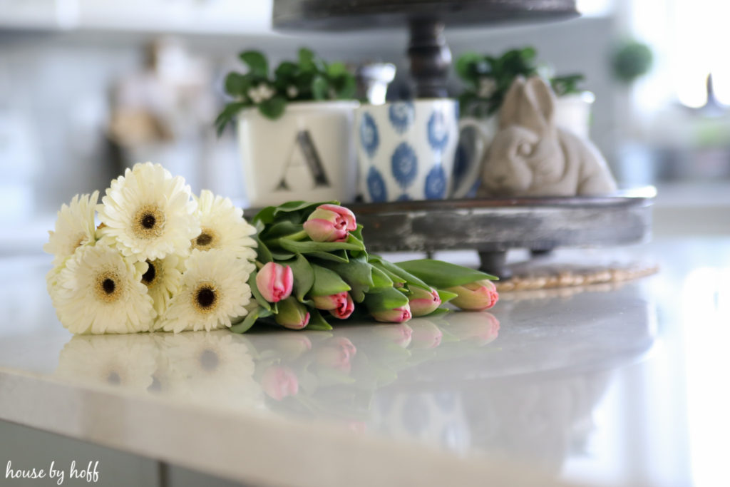 Flowers lying on the white kitchen island.