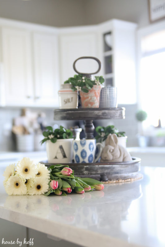 Flowers and a tiered tray on the kitchen island.