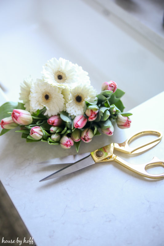 Fresh flowers and scissor beside each other.