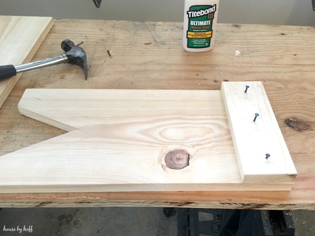 A hammer, nails and glue on the work table.