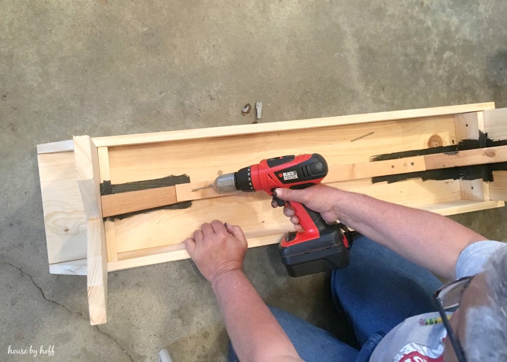 Using an electric screw driver on the bench.