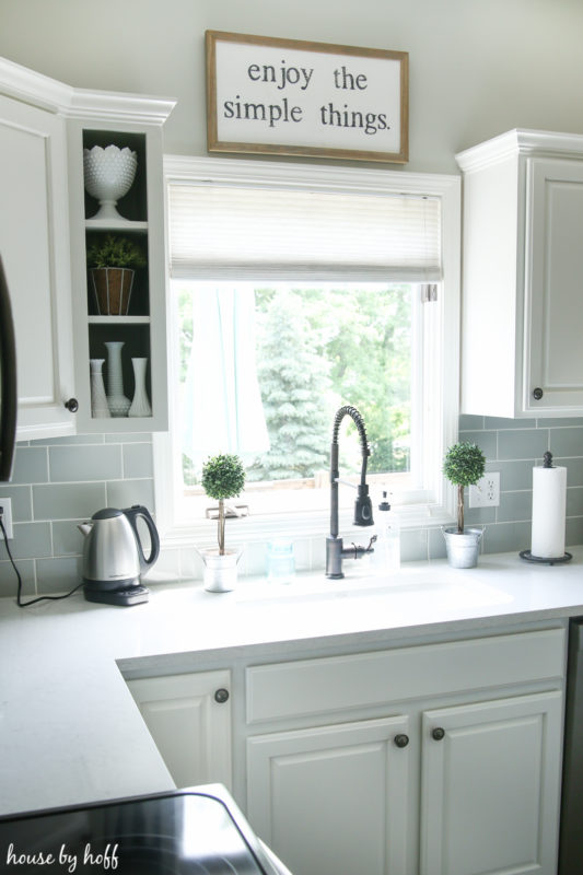 The blinds in the kitchen behind the sink.