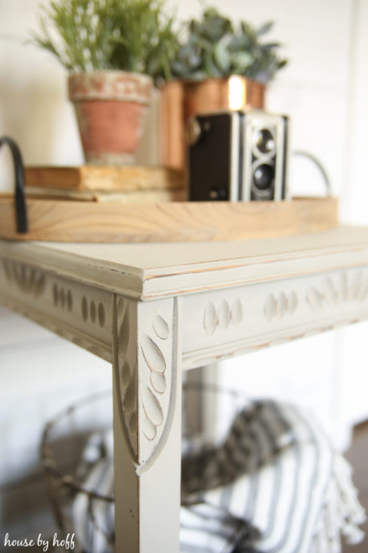 Side table painted with a chalky finish and plants on the table.