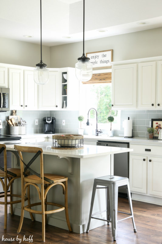 The white kitchen island with wooden chairs.