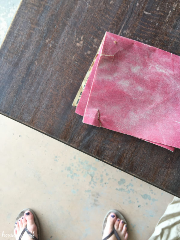 Sanding the brown worn out table.