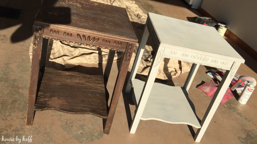 A brown worn out table and the refinished table side by side by garage.