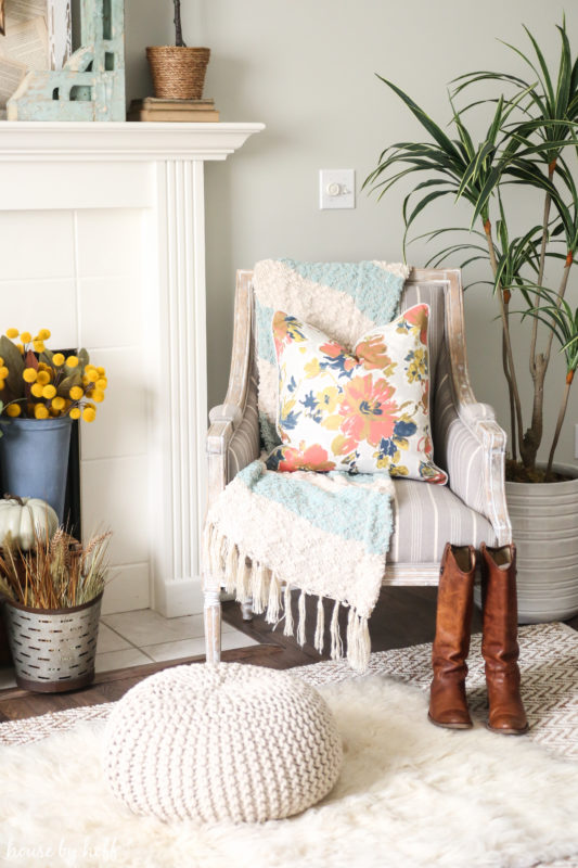 Faux white fur rug, cowboy boots in front of fireplace.