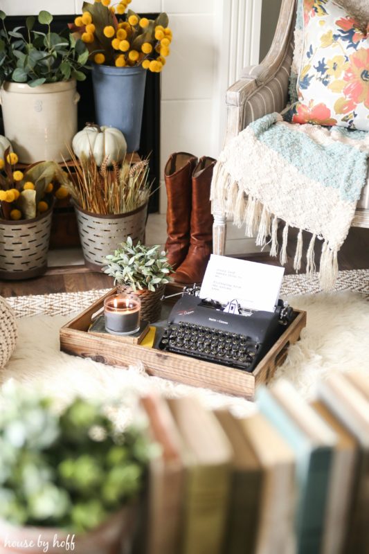 Typewriter on floor in front of fireplace.