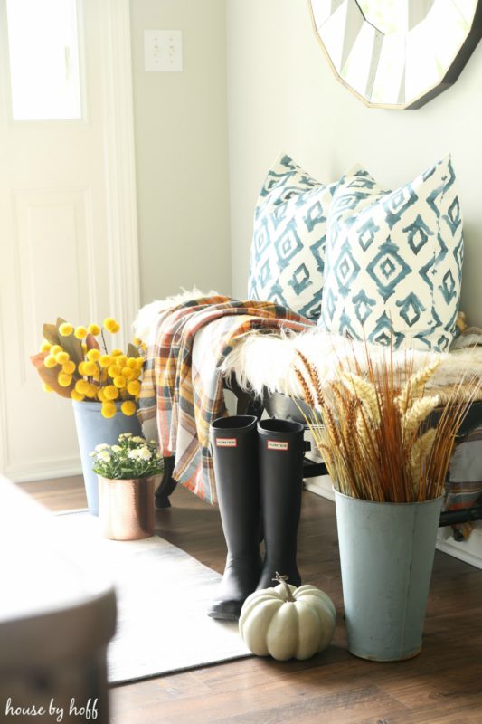 Front door, side bench boots and a pumpkin in the entryway.