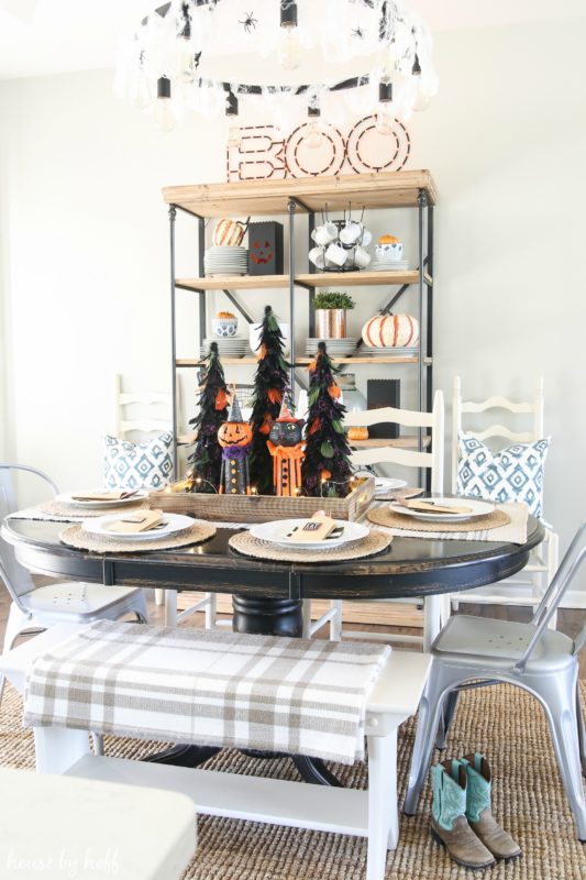 Wooden dining room table with cute pumpkin cats and cowboy boots by table.