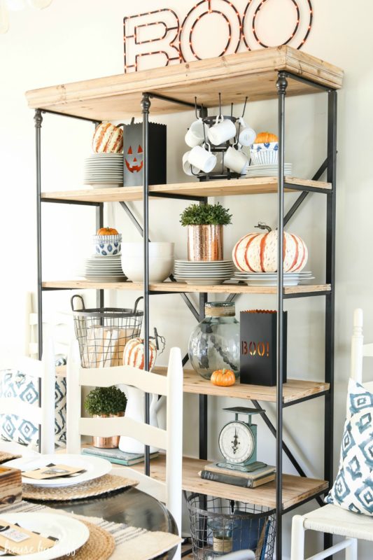 Open shelving unit with Boo sign on top of it, lit up.