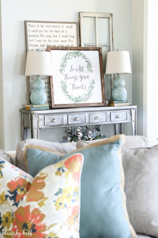 Side table with the November vignette on it and pillows in the foreground.