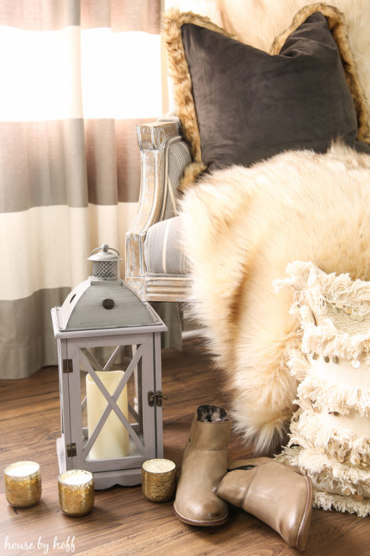 Faux fur, candles and boots in living room.