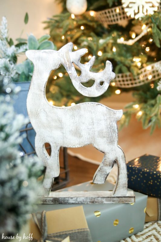 A wooden reindeer brushed with white pain on a present.