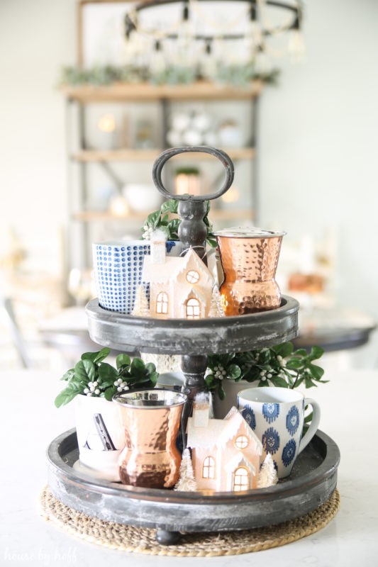 Metal tiered tray with Christmas ornaments on it.