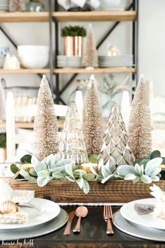 Bottle brush sparkly Christmas trees as a centrepiece on table.