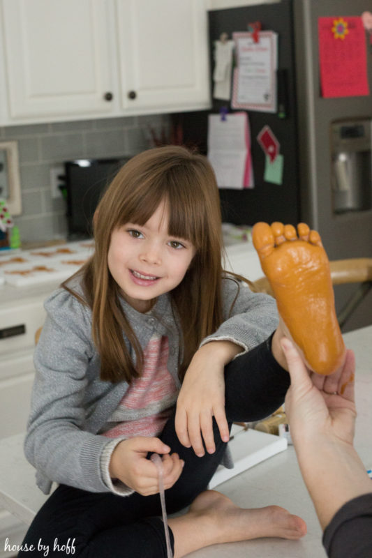 Paint on little girls feet while she sits on the counter.