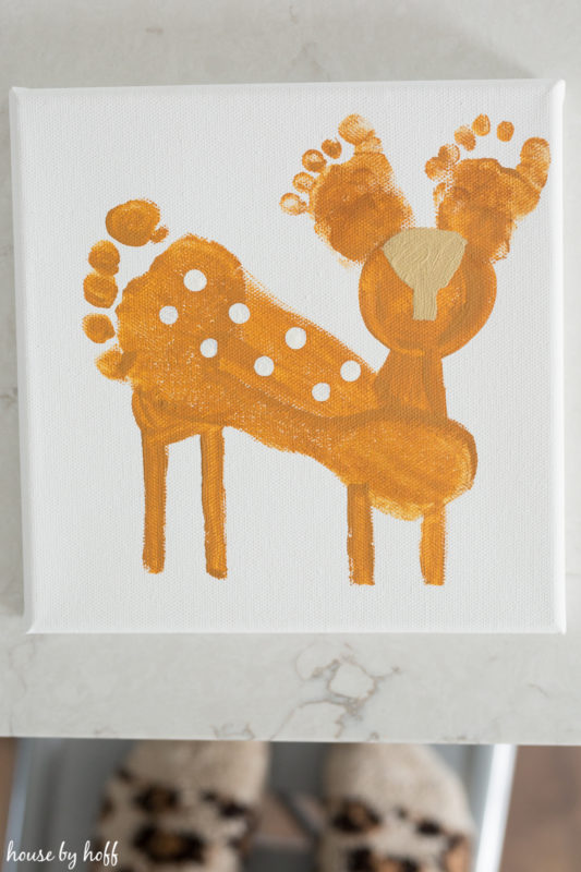 White canvas with a painted deer art from a foot.