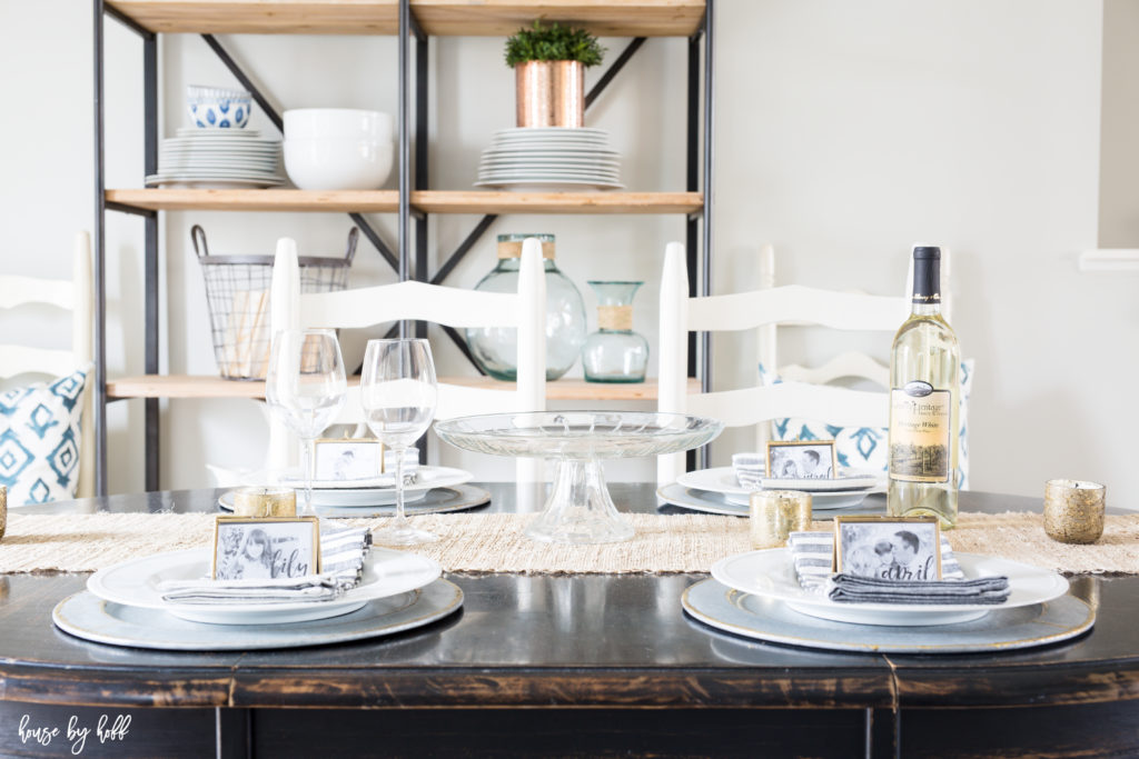 Striped blue and white napkins on the table and a bottle of white wine.