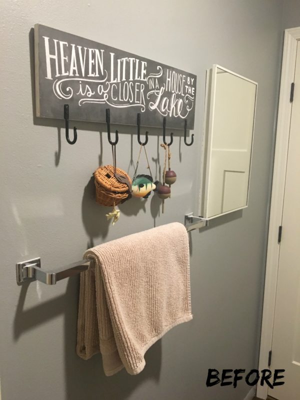 A metal towel rack with a towel on it, and a cute sign above it.