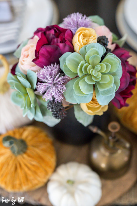 Multicolored plants in vase on table.