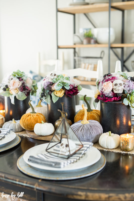 Velvet pumpkins and skulls on table.