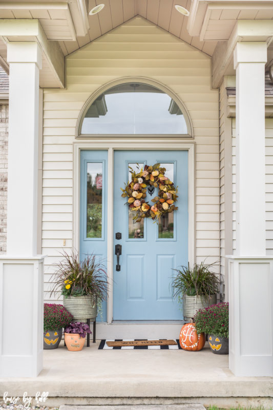 Front porch with 2 columns on it and planters on the porch.