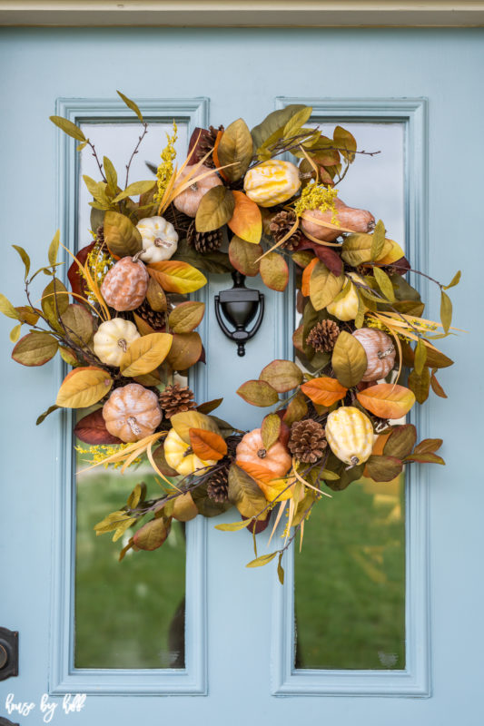 Multicolored wreath on the light blue front door.