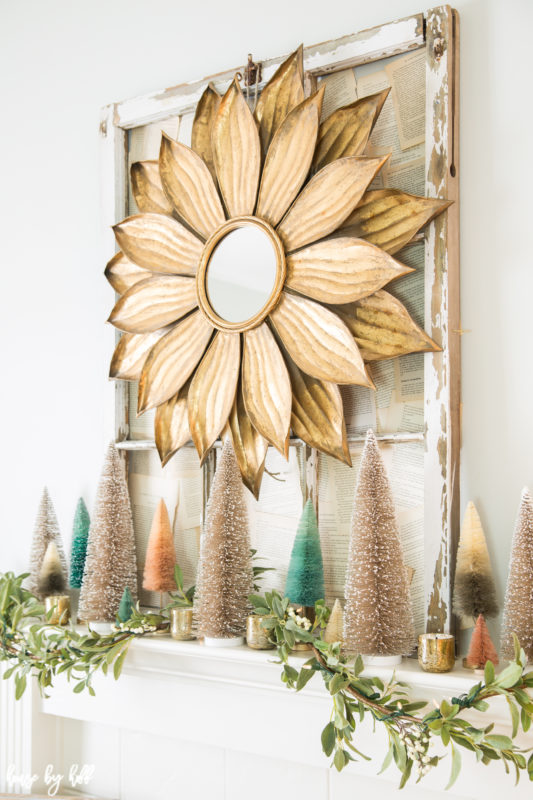 Large metal flower mirror above the mantel.