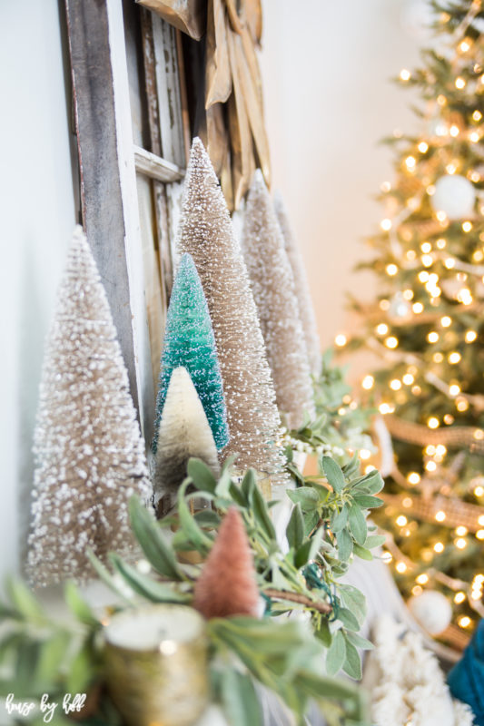 Flocked mini trees on the fireplace mantel.