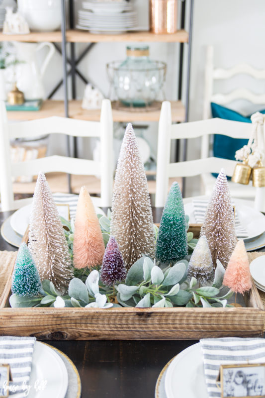 Little Christmas trees and eucalyptus on the table.