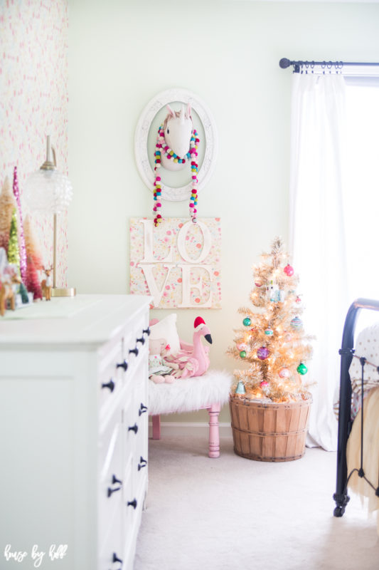 There is a Pom Pom string around a unicorn head in the bedroom.