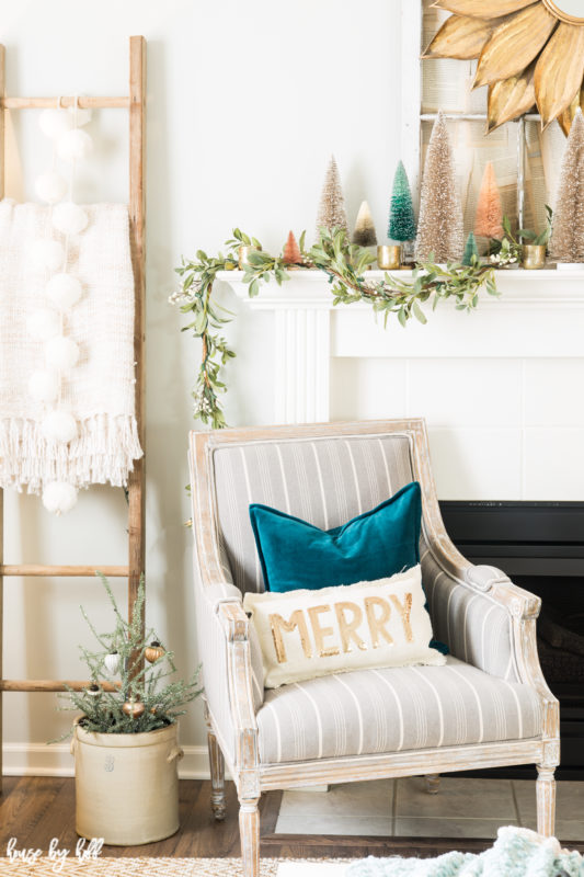 Turquoise blue velvet pillows on the armchairs in front of the fireplace.