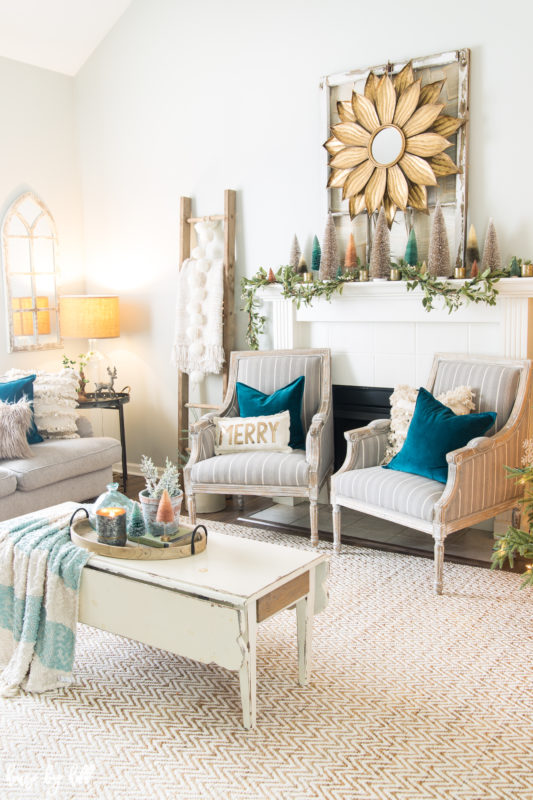 Two chairs flanking a fireplace with a wooden coffee table and tray on it.