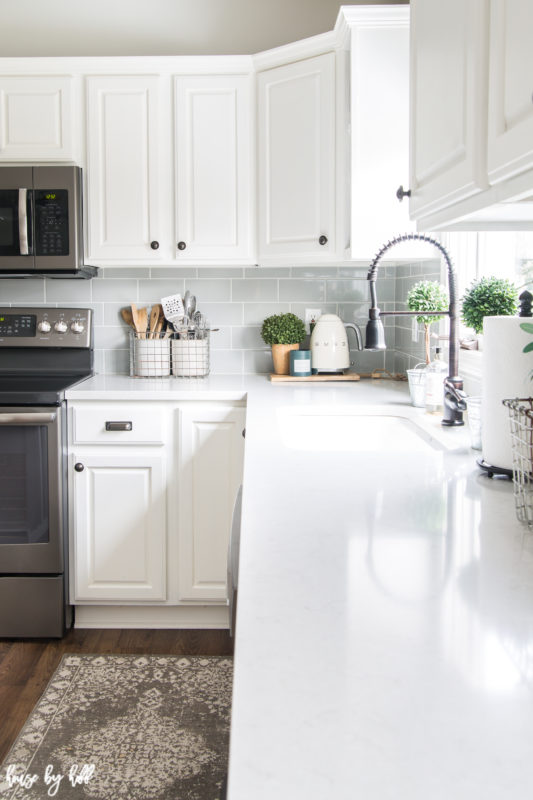 Gray and White rug in front of the kitchen sink.