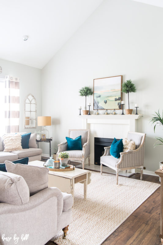 A white rug is in the middle of the living room with a white coffee table on it.