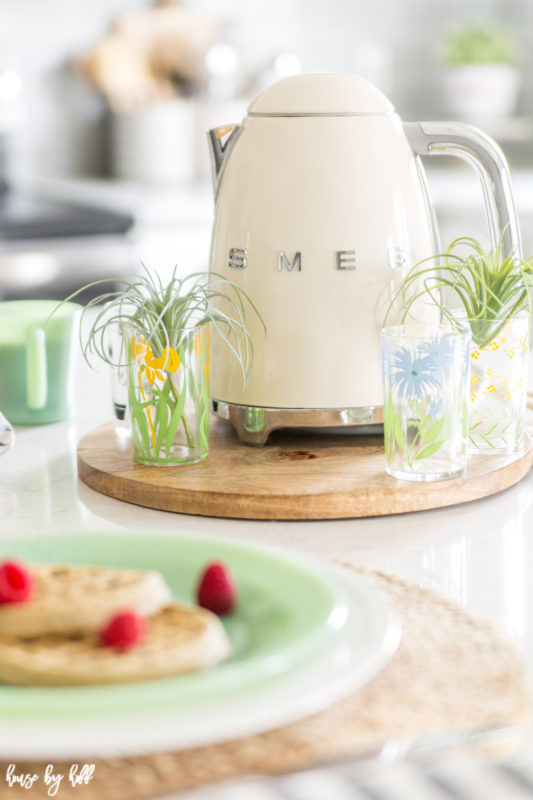 The Smeg kettle and antique glasses filled with greenery.