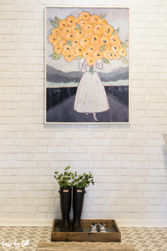 White Painted Brick Removable Wallpaper on the walls, plus a picture of a woman holding flowers and shoes underneath it.