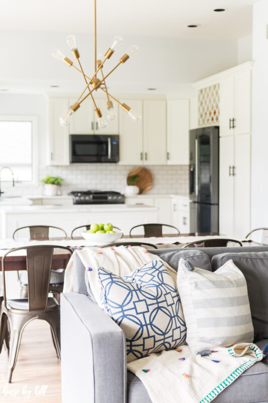 A grey couch with graphic pillows are in the living room.