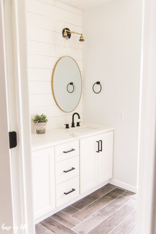 Renovated Guest Bathroom with Shiplap and Brass Light Fixtures.