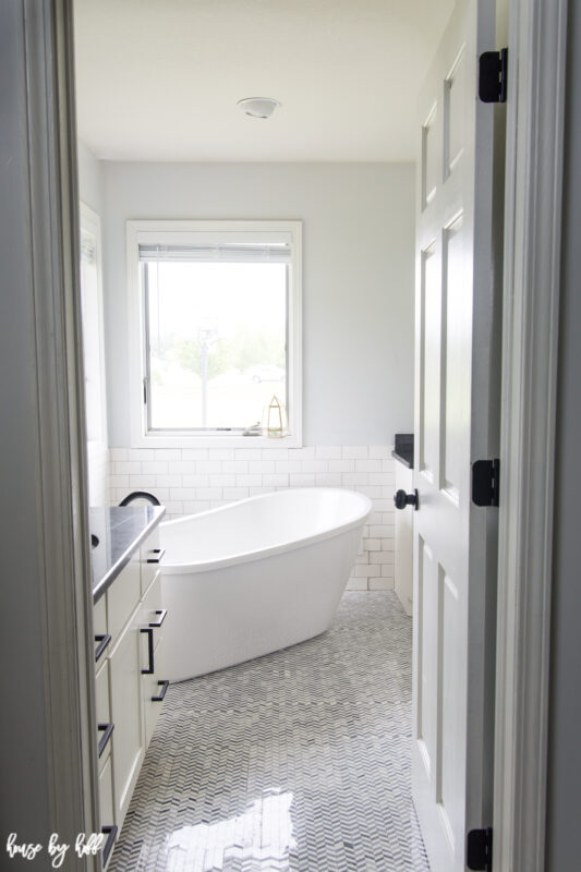 Renovated Master Bathroom with Chevron Tile and Standing Tub.