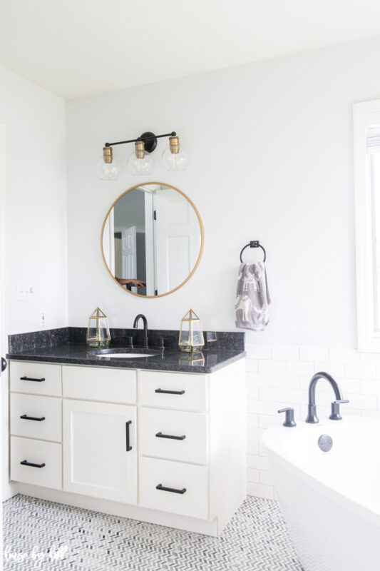 A round mirror in the bathroom with a gold rim.