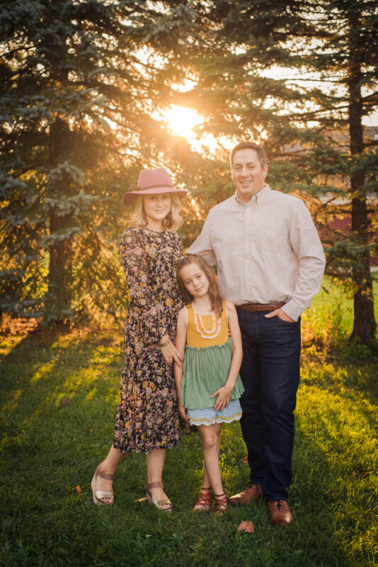 April, her husband and daughter posing for a picture outside.
