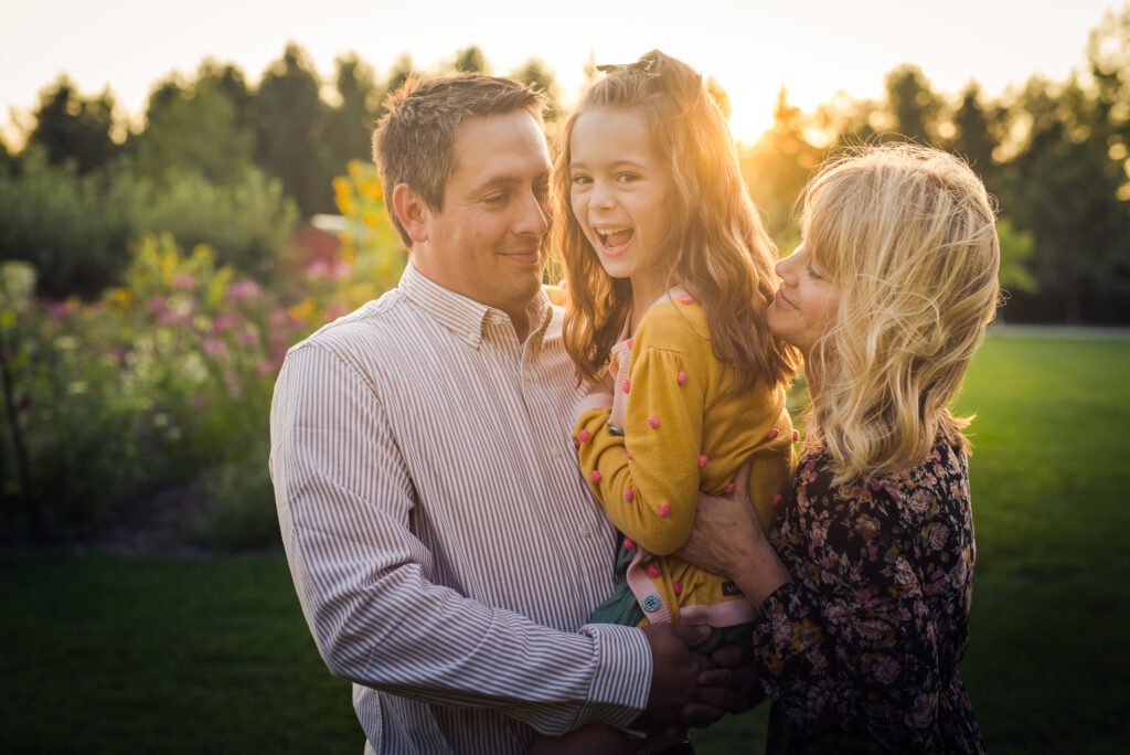 The little girl in her Dad's arms with mom holding her to.