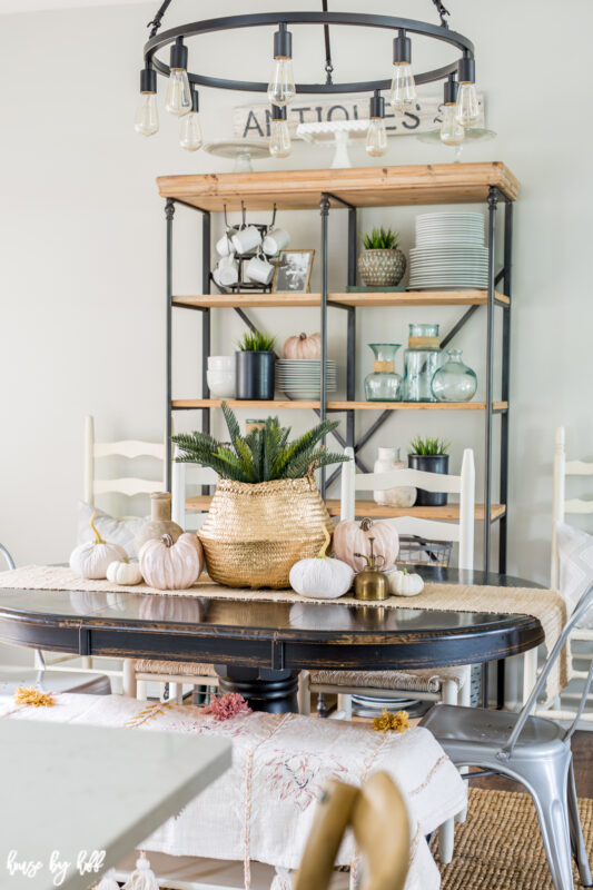 An open shelving unit is behind the dining room table.