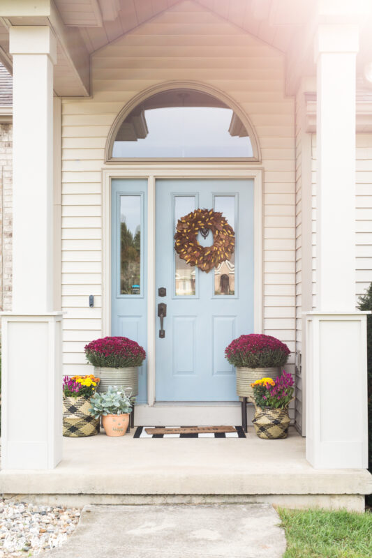 Fall Front Stoop with Blue Door and purple flowers.