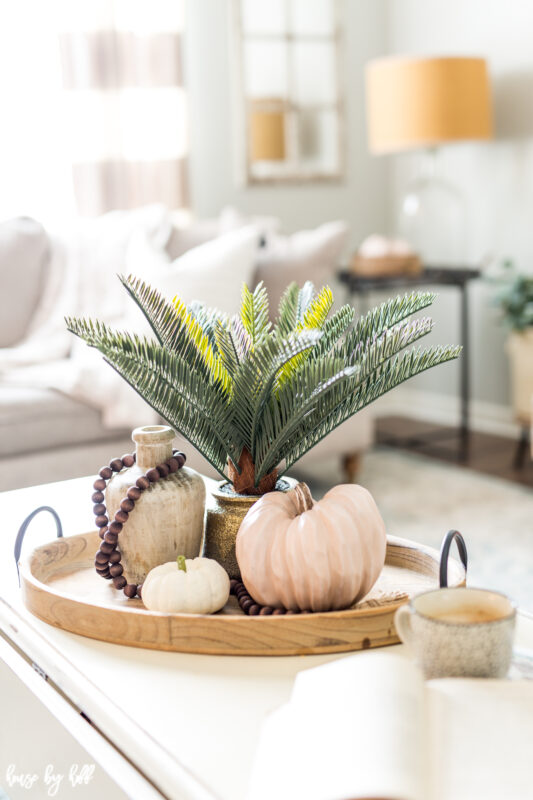 Wooden Tray with Simple Fall Decorations such as a neutral pumpkin, and wooden vase.