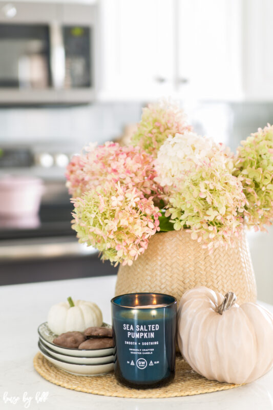 Hydrangea Centerpiece for Fall with a sea salted candle and pumpkins beside it.